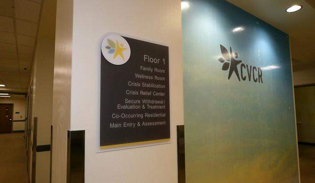 A colorful logo wall and a sign listing treatment areas is displayed in the public entrance to the Columbia Valley Center for Recovery in downtown Kennewick.